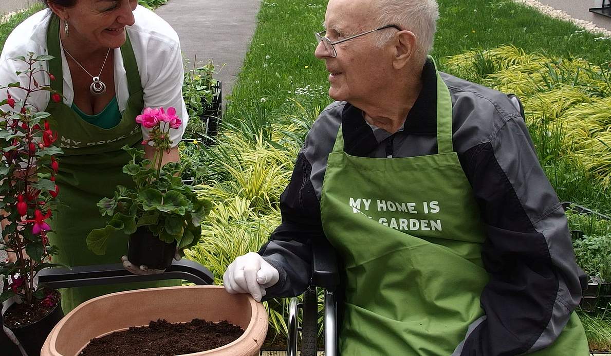 Ein Bewohner und eine Betreuerin im Garten.